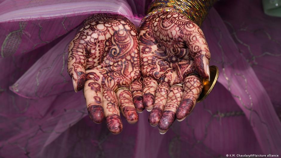 Eine muslimische Frau bemalt ihre Hände mit traditionellem Henna, während sie in der historischen Badshahi-Moschee in Lahore, Pakistan, das Eid al-Fitr-Gebet verrichtet, dass das Ende des Fastenmonats Ramadan markiert.