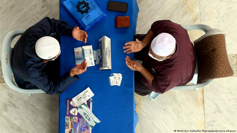 Ein Pilger zahlt die Zakat al-fitr, eine religiöse Abgabe, die am Ende des Fastenmonats Ramadan an Bedürftige gespendet wird.