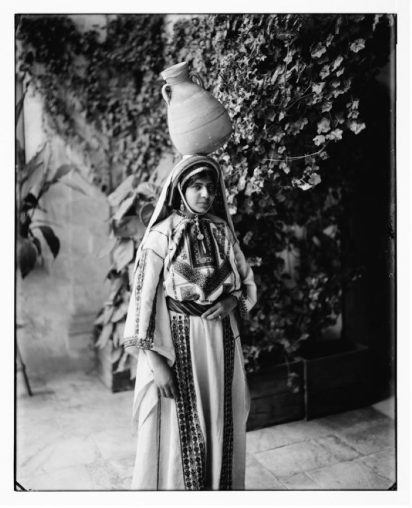 Eine junge Frau in einem mit traditionellen tatreez-Stickereien gearbeiteten Kleid