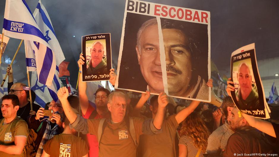 Relatives and supporters of Israeli hostages held in Gaza since the October 7 attacks by Hamas militants hold pictures of 47-year-old hostage Elad Katzir, and wave Israeli flags during a demonstration in front of the Defence Ministry in the Israeli coastal city of Tel Aviv