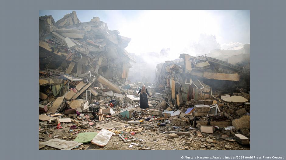 A Palestinian woman stands alone amidst the rubble of bombed out houses in Gaza