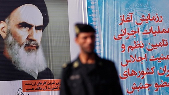 Ein syrischer Polizist und ein überlebensgroßes Plakat von Ayatollah Khomeini in Teheran; photo: DW
