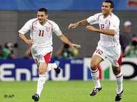 Tunisia's Santos, left, is congratulated by teammate Jawhar Mnari after scoring the opening goal during the Confederations Cup Group A soccer match between Australia and Tunisia in Leipzig, Germany June 2005 (photo: AP)