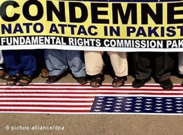 Pakistaner in Hyderabad treten auf die Amerikanische Flagge und demonstieren mit einem Plakat gegen den Nato-Luftangriff; Foto: dpa