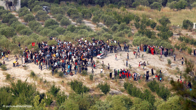 Syrian refugees attend a funeral of an anti-regime protester on the Syria-Turkey border, near the Turkish village of Guvecci, in Hatay, Turkey 11 June 2011. The number of Syrians who took refuge in Turkey from a violent crackdown of anti-government protests in Syria has reached approximately 10,000. Turkish Prime Minister Recep Tayyip Erdogan has said Turkey was concerned over incidents in Syria as the Assad government escalates violence against civilians in a crackdown of anti-government protes