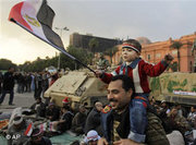 An Egyptian man carrying his son on his shoulders during a demonstration in Tahrir Square (photo: AP)