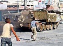 Palestinian children throw stones at an Israeli tank in the West Bank town of Jenin (photo: AP)