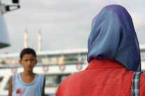 Woman wearing the Muslim headscarf, a boy in the background (photo: Sirvan Sarikaya)