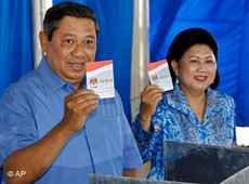Indonesian President and presidential candidate Susilo Bambang Yudhoyono shows his vote, along with his wife Kristiani Herawati, before casting their ballots at a polling station (photo: AP)