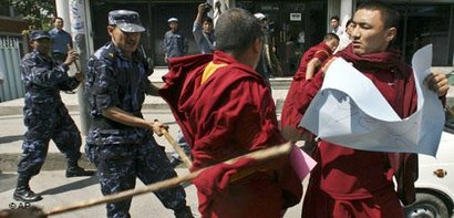 Policemen chase away protesters as Tibetans demonstrate against Chinese rule in Tibet (photo: AP)