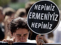A demonstrator weeps as she holds a placard that reads: 'We are all Armenians' near a courthouse in Istanbul (photo: AP)