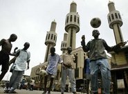 Nigerian youths playing soccer in front of a mosque (photo: AP)