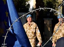 UN soldiers, seen behind barbed wire and a EU flag, cross the Ledra Palace checkpoint in Nicosia, Cyprus, December 2004 (photo: AP)