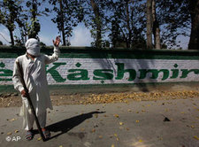 A masked Kashmiri protester signals to fellow protesters as they block the road during a protest against the arrest of youths, on the outskirts of Srinagar (photo: AP)