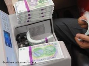 آلة عد النقود وفيها أوراق نقدية من الدينار التونسي. Picture alliance 