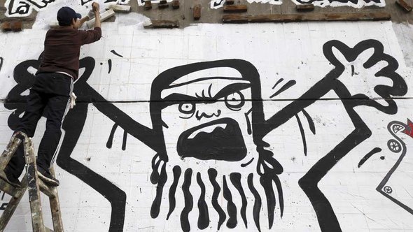 Mann in Kairo malt Graffiti der Muslimburderschaft; Foto: Reuters