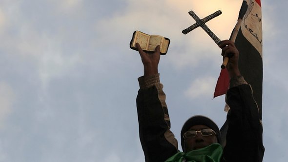 Ein Gegner Mohammed Mursis hält in Kairo vor dem Präsidentenpalast den Koran und ein Kreuz hoch; Foto: Reuters