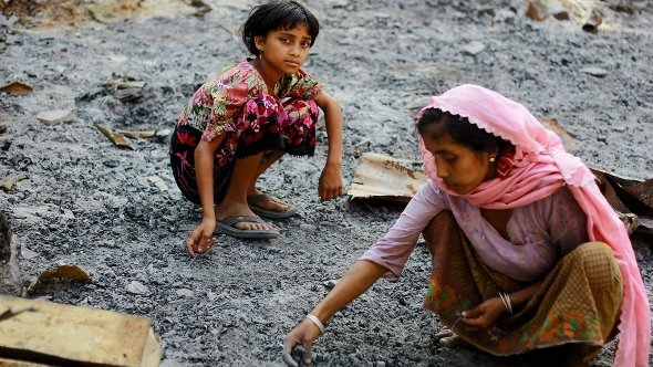 Zwei Rohingiya-Mädchen wühlen in der Asche ihrer abgebrannten Behausungen nach Wertsachen; Foto: Reuters