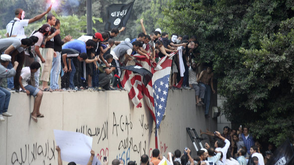 Demonstranten auf der Mauer der US-Botschaft in Kairo; Foto: dapd