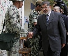 Mohammed Morsi, Sprecher der Muslimbruderschaft, schüttelt einem Soldaten die Hand; Foto: AP