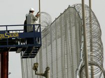 Arbeiter befestigt einen Stacheldrahtzaun an der Grenze zu Melilla, Foto: AP