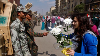 Ägypterin überreicht Blumen an zwei Soldaten auf dem Tahrir-Platz in Kairo; Foto: dapd