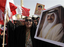 Porträts des bahrainischen Ministerpräsidenten Khalifa bin Salman Al Khalifa und des Königs Hamad bin Isa Al Khalifa werden während einer Pro-Regierungsdemonstration emporgehalten; Foto: Hassam Ammar/AP