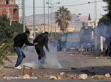 Jugendliche Demonstranten werfen Steine gegen Sicherheitskräfte in der Provinzstadt Regueb, nahe Sidi Bouzid; Foto: AP
