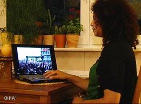 Bloggerin schaut sich am Laptop ein Video von Demonstrantionen in Tunesien an; Foto: DW