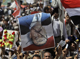 Demonstranten halten ein Plakat mit einem durchgestrichenen Foto von Ali Abdullah Saleh hoch; Foto: dapd