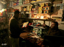 Ein Palästinenser sitzt in seinem Laden bei Stromausfall mit einer Laterne; Foto: AP 