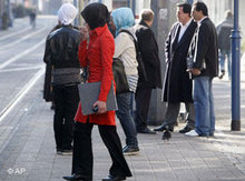 Fauen mit Kopftuch warten in Duisburg an einer Bushaltestelle; Foto: AP