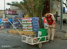 Irakischer Junge füllt Plastikbehälter mit Wasser auf; Foto: DW TV