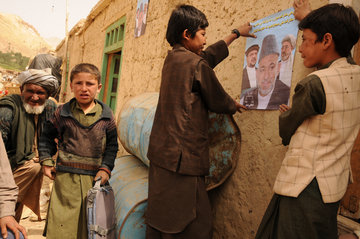 Afghanen vor Wahlplakaten in Kabul; Foto: Martin Gerner