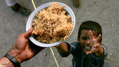 Pakistanischer Junge streckt die Hände zu einem Teller Essen hoch; Foto: AP