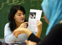 Lehrerin vor einer Schülerin mit Kopftuch; Foto: dpa
