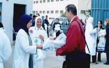 CDG-Mitarbeiter verteilt Infobroschüren an zwei Arbeiterinnen in Fes; Quelle: Centre des Droits des Gens (CDG) 2004