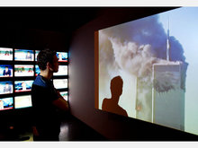 Mann beobachtet die Ereignisse vom 11. September auf einer Leinwand; Foto: dpa