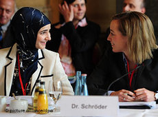 Bundesfamilienministerin Kristina Schröder auf der Islamkonferenz im Gespräch mit einer Muslima; Foto: dpa