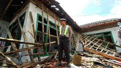 Ein Polizist steht vor dem zerstörten Haus eines Ahmadiyah-Mitglieds in Pandeglang; Foto: AP