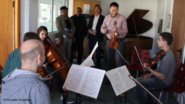 Martin Kögel vom Deutschen Symphonie Orchester Berlin mit Schülern im Westjordanland; Foto: Mustafa Khadeisa/DW