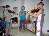 Geigenlehrerin Tania Beltzer mit ihren Schülern David (l.) und Habib (r.); Foto: DW