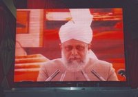 Hazrat Mirza Masroor Ahmad on an oversize video screen (photo: Andreas Gorzewski)