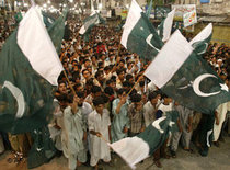 Pakistanische junge Männer schwenken am Unabhängigkeitstag die Nationalflagge; Foto: AP