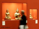 Besucher betrachtet buddhistische Figuren, Foto: Roland Weihrauch, DPA