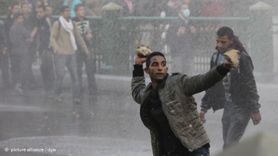 متظاهر مصري يقذف قوات الأمن بالحجارة.dpa