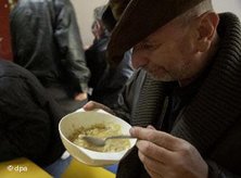 Homeless man with a bowl of soup (photo: dpa)
