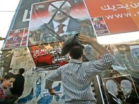 فلسطينيون غاضبون يلقون بأحذيتهم على صورة للرئيس محمود عباس، الصورة أ ب