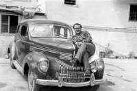 رجل يجلس على غطاء محرك سيارته، الصورة: المؤسسة العربية للصورة