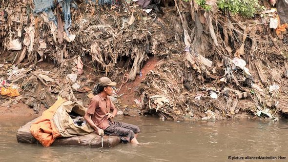 Leben im Müll am Fluss Ciliwung in Jakarta. Mann fischt auf Müllfloß nach Müll; Foto:dpa